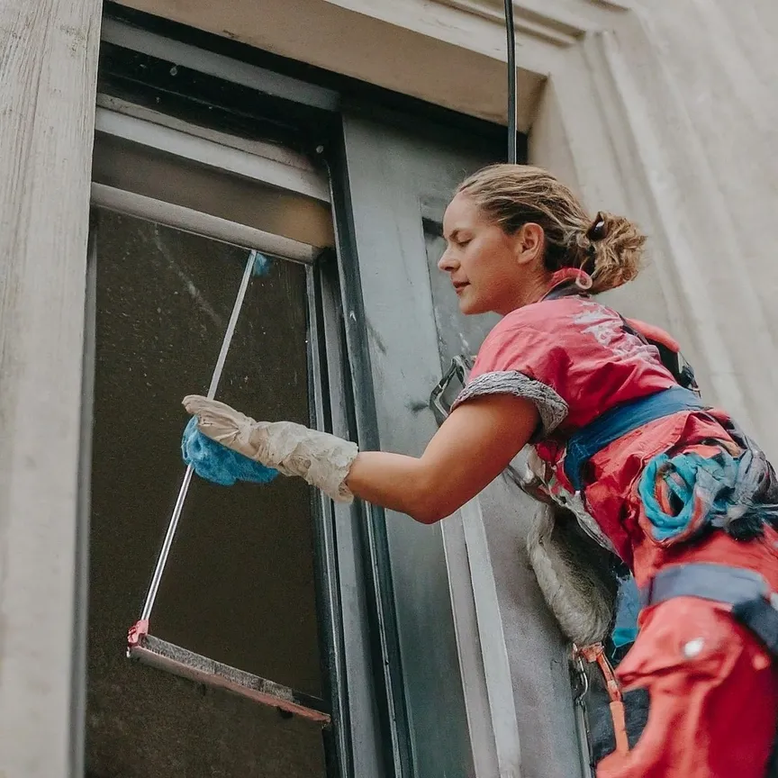 persona limpiando una ventana alta